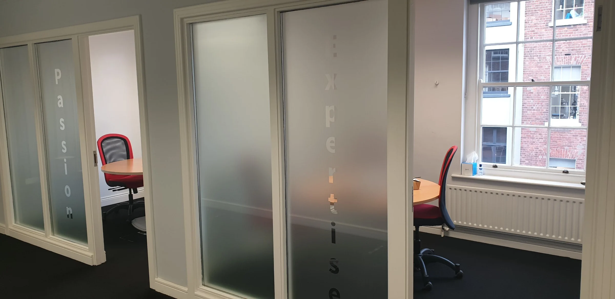 Two small meeting rooms with frosted glass doors in the Dublin office, used for one-to-one tests with students